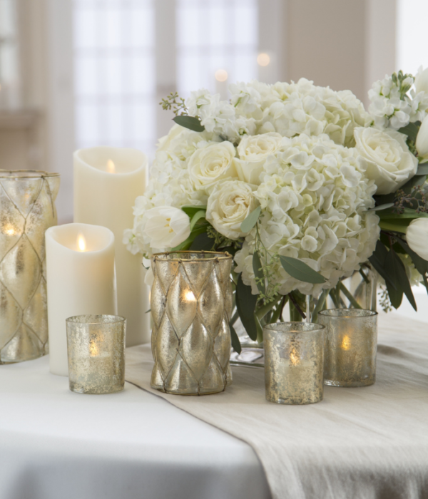 Flameless candles for wedding reception table centerpieces with flowers, candle holders