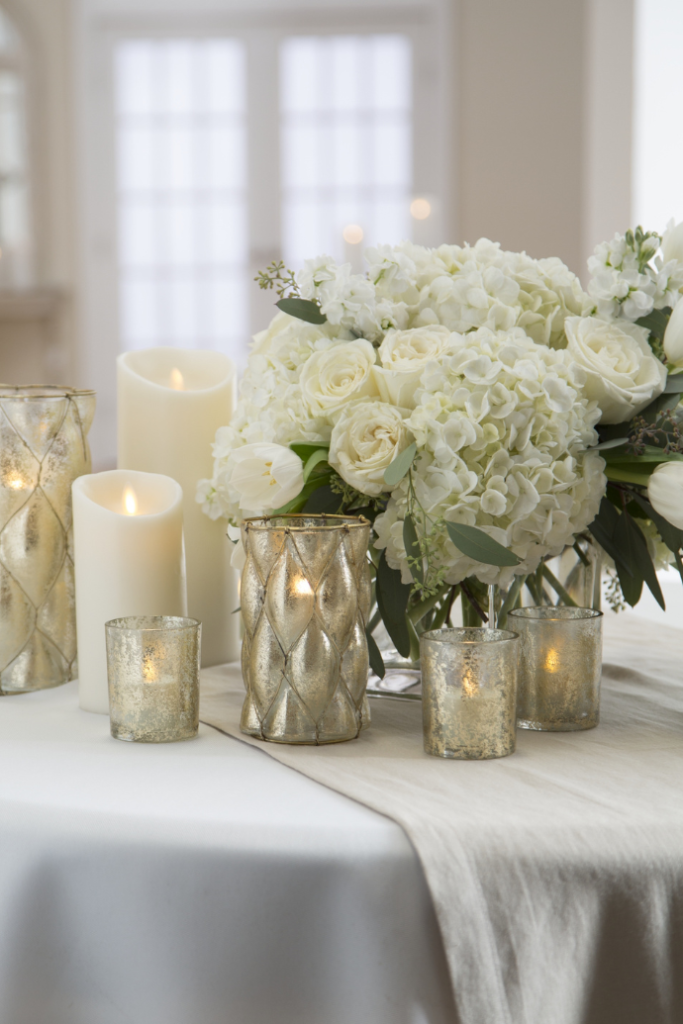 Flameless candles for wedding reception table centerpieces with flowers, candle holders