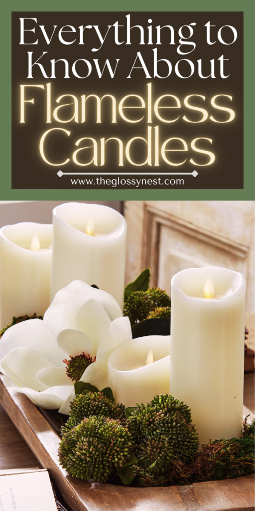 A group of flameless candles in a wooden tray, surrounded by green foliage and white flowers, with text above reading "Everything to Know About Flameless Candles" and a website URL below.