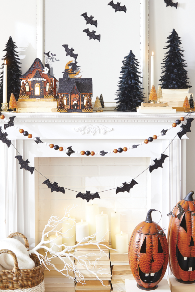 Cute ways to decorate for a Halloween fireplace & mantel with haunted houses, bat garland, pumpkins, candles