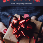 A person holds a wrapped Christmas gift with a red ribbon and bow. The image features the text "How to Plan Christmas Gifts," and a website "www.theglossynest.com" is also displayed.