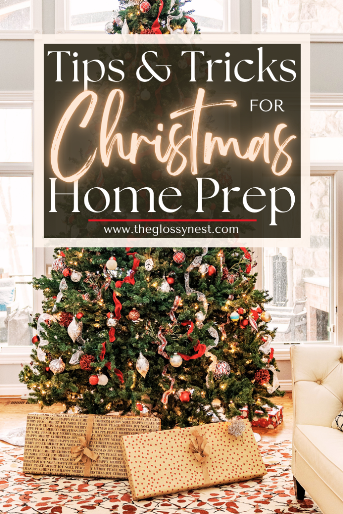 A beautifully decorated Christmas tree adorned with ornaments and surrounded by wrapped gifts. The tree is set in a cozy, light-filled room. A sign above reads, "Tips & Tricks for Christmas Home Prep" from theglossynest.com.