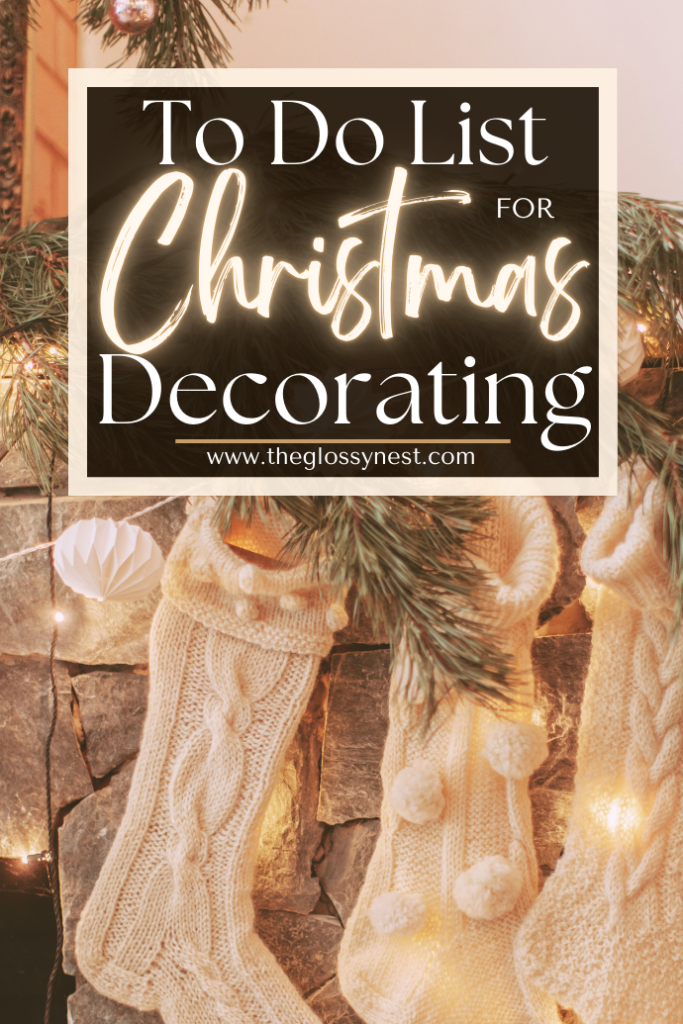 A cozy Christmas scene features knitted stockings hanging on a stone fireplace, adorned with pine branches and warm lights. A glowing sign reads, "To Do List for Christmas Decorating" with a website link, www.theglossynest.com.