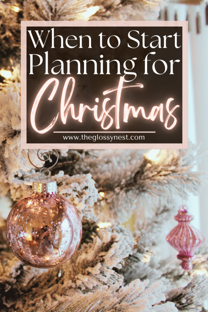 A festive Christmas scene featuring a frosted tree adorned with pink and rose-gold ornaments. A sign reads, "When to Start Planning for Christmas" from theglossynest.com.