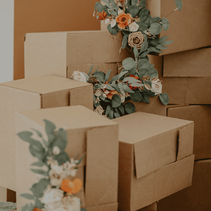 Cardboard boxes with faux greenery garland.