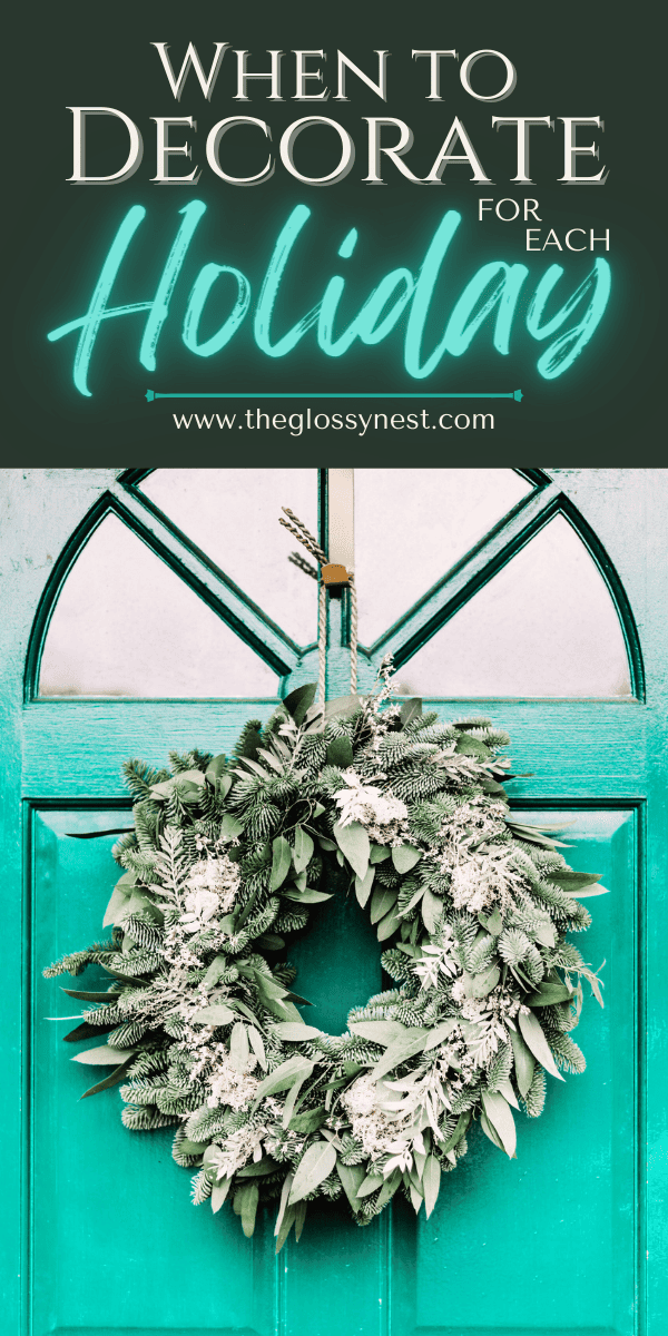 Wreath with winter greenery hanging from a teal front door