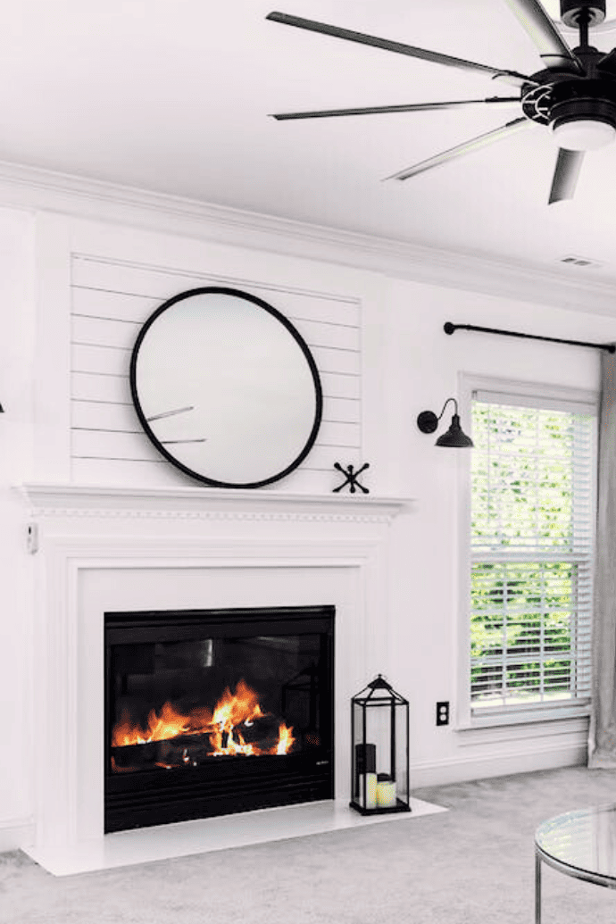 electric fireplace with white shiplap, mantel, mirror, lanterns in living room