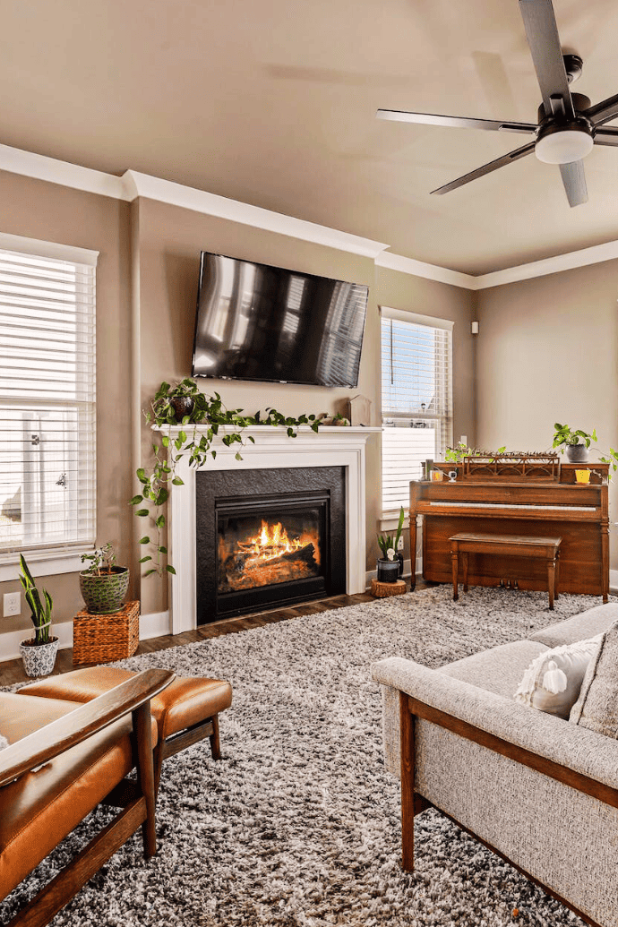 electric fireplace with plants, mantel, tv above in living room