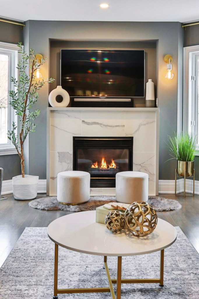 marble fireplace with tv, sound bar mounted above mantel, with plants, vases