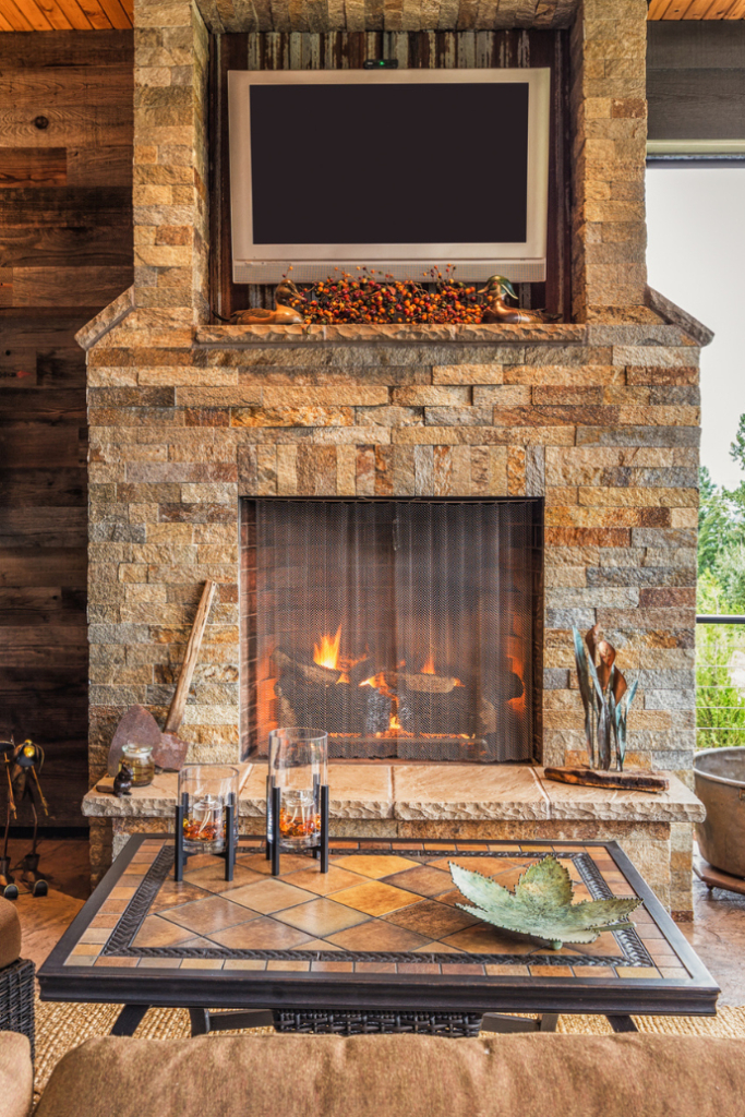 outdoor fireplace with tv in niche above the mantel