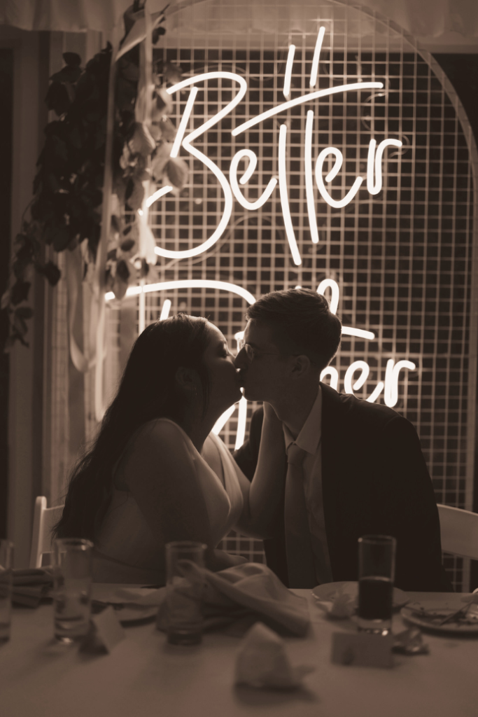 better together wedding neon sign behind sweetheart table