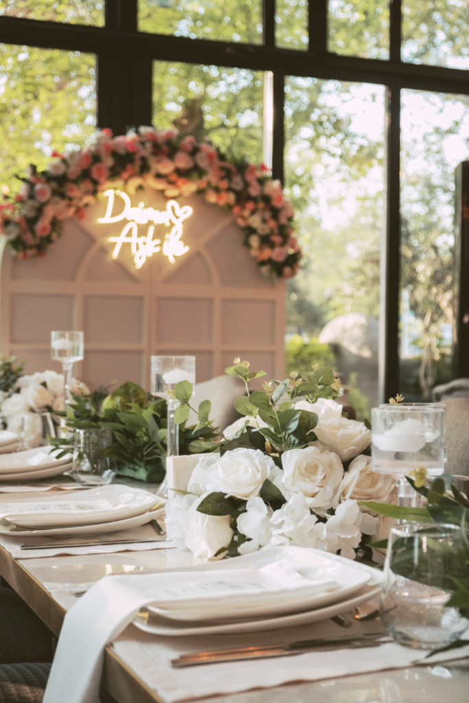 wedding neon sign with florals on wood arch backdrop at reception