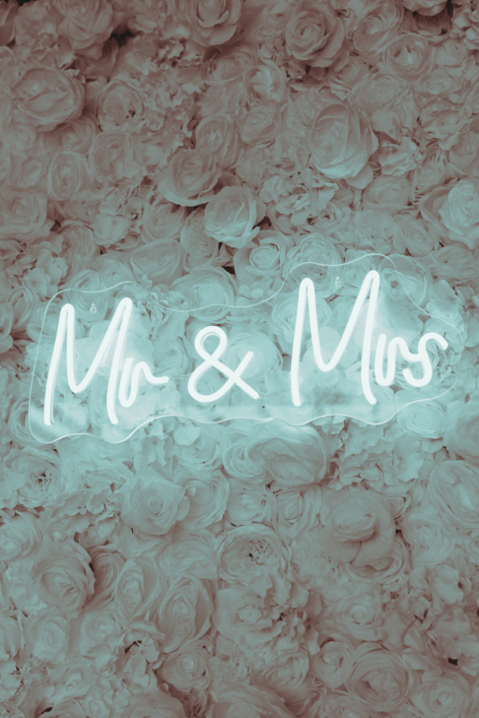 mr and mrs wedding neon sign with floral wall backdrop