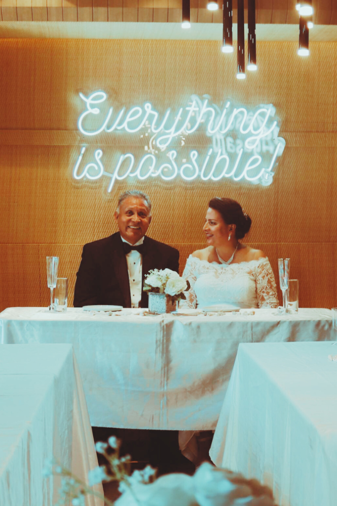 everything is possible wedding neon sign behind sweetheart table