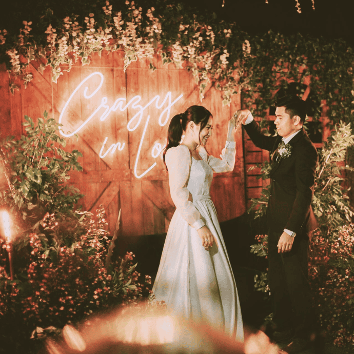 crazy in love wedding neon sign against wood barn door backdrop