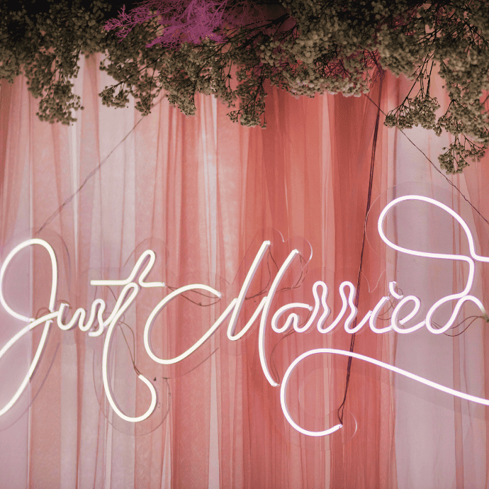 just married wedding neon sign with curtain backdrop, greenery