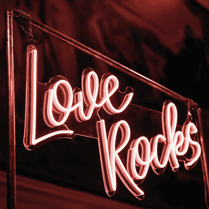 love rocks wedding neon sign hanging from stand