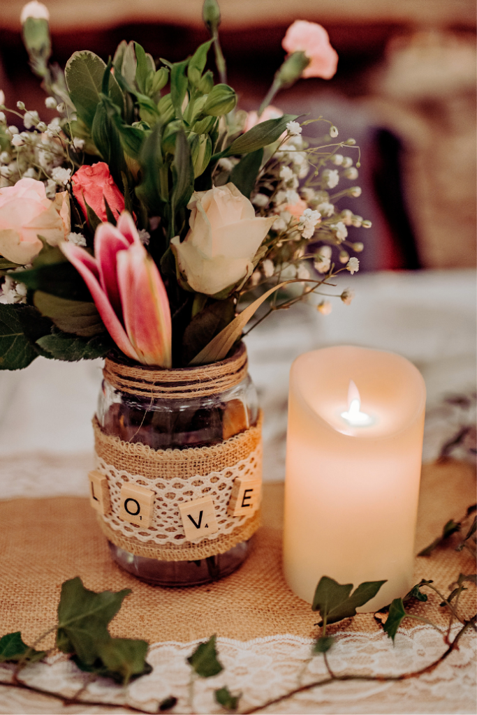 flameless candle, burlap, flowers in mason jar vase for wedding reception