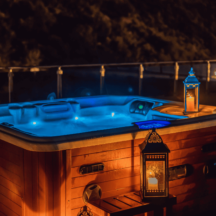 lanterns next to a hot tub at night
