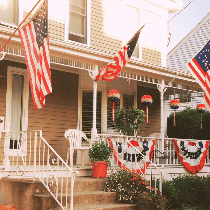 front porch with fourth of july decorations, bunting, american flags