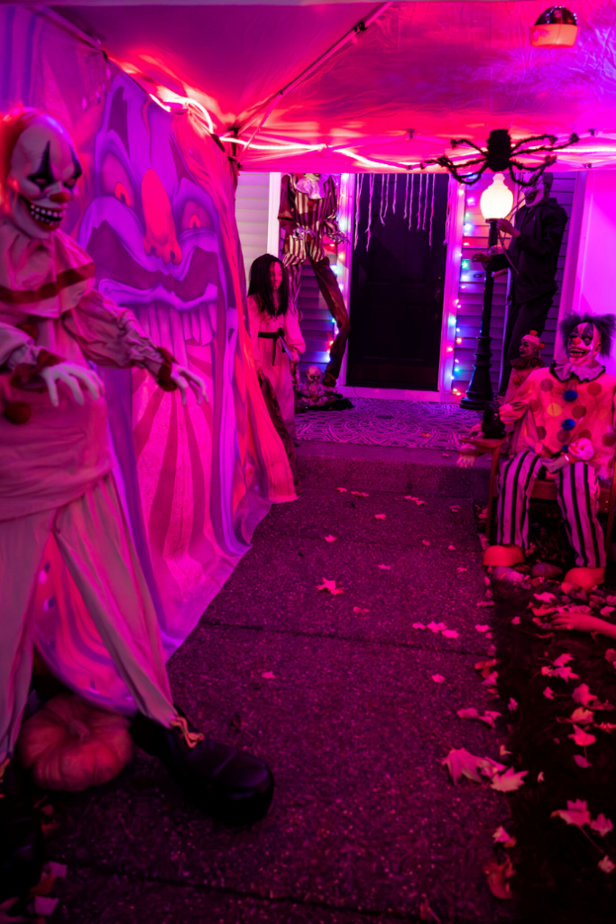 creepy clown in front yard for halloween with pink lighting