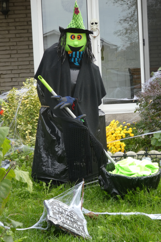 cute halloween witch with cauldron outside in front yard