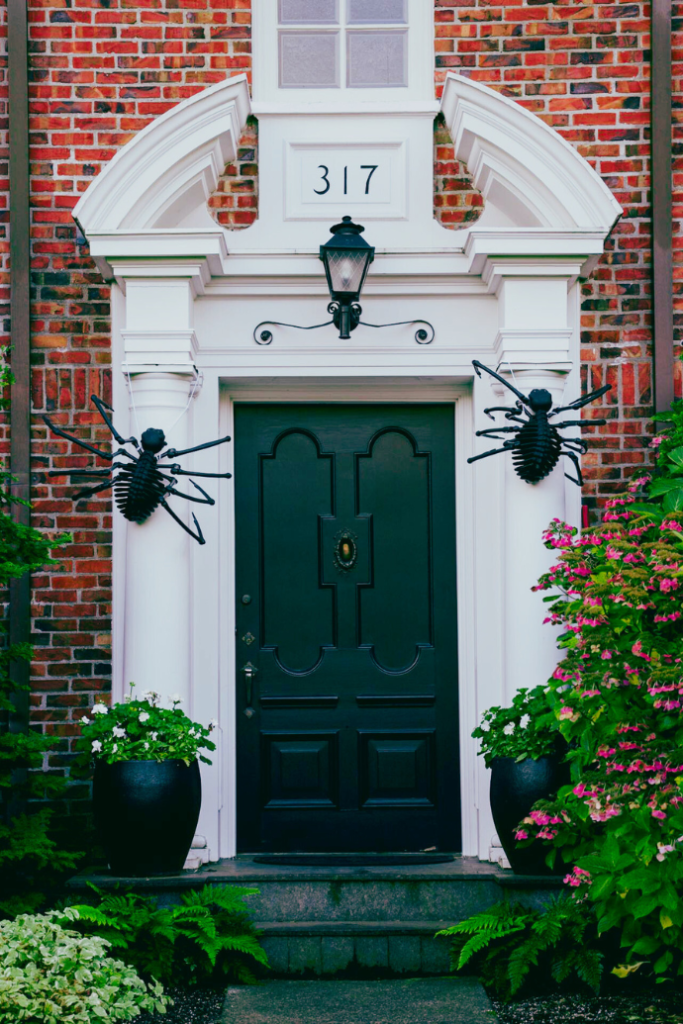 halloween front door with spiders, planters