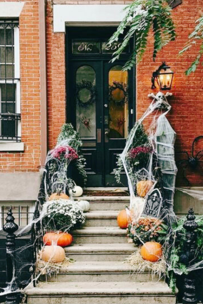 halloween front porch with mums, pumpkins, cobwebs, skull, memory