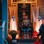 halloween front porch decorated with ghosts, skeletons, mum, jack-o-lantern