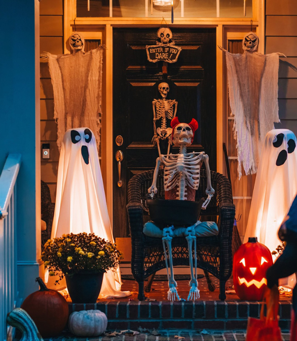 halloween front porch decorated with ghosts, skeletons, mum, jack-o-lantern