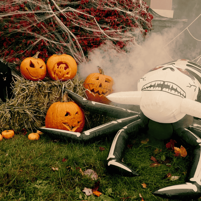 blow up spider, spider webs, jack-o-lanterns in halloween front yard display