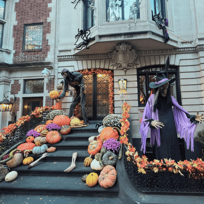 witch figurine, tall bog monster, pumpkins, gourds, mums in halloween front yard display