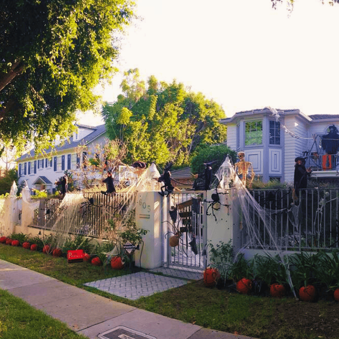 spiders, witches, pumpkins, gate, fence in halloween front yard display