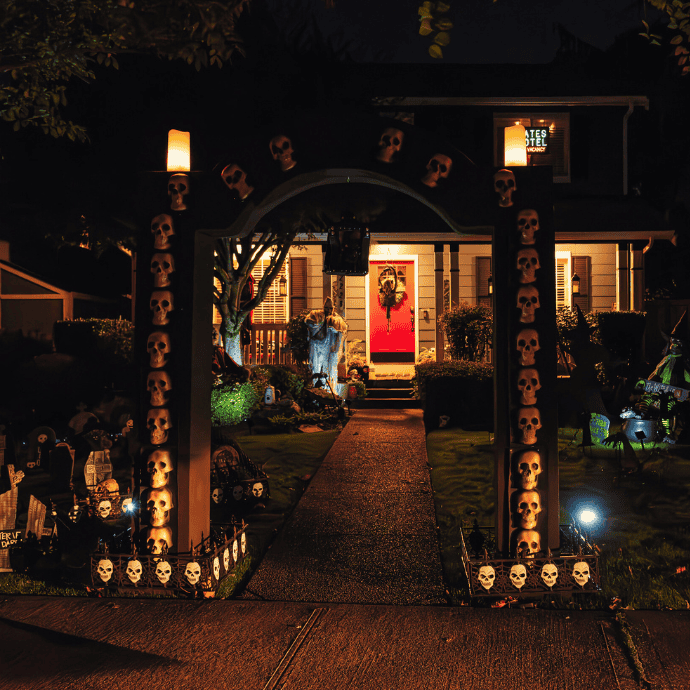 arch with skulls by walkway in halloween front yard display