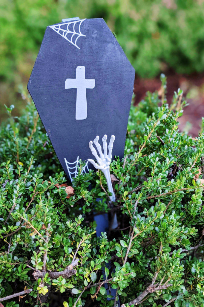 tombstone, hand decor in bush for halloween