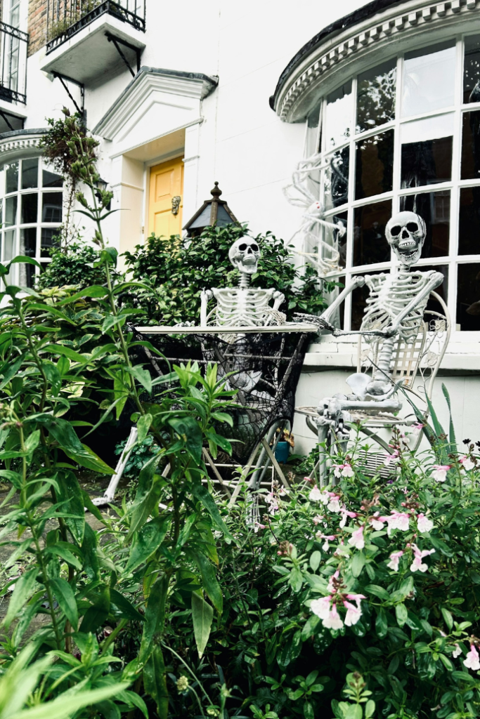 skeletons sitting at table in garden for halloween