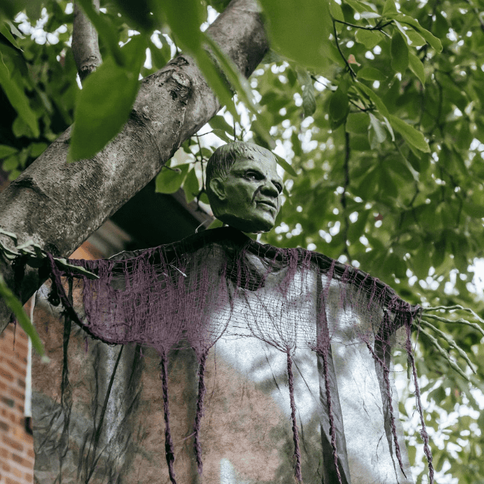 halloween monster figurine hanging from tree in garden