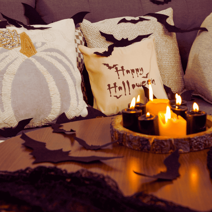 halloween pillows, couch, candle centerpiece, bats