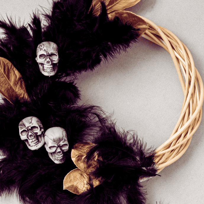 elegant halloween wreath with feathers, skulls, gold leaves