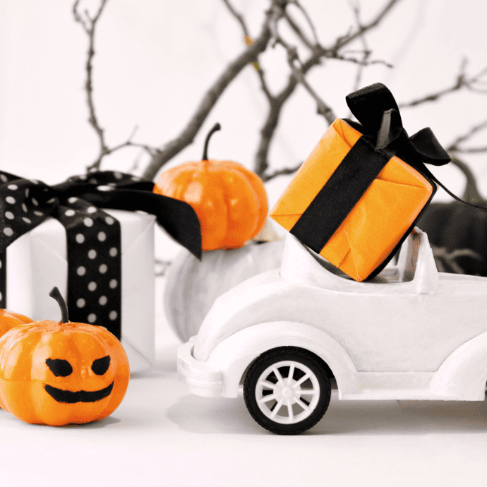 cute halloween decorations with orange, black, white car, presents, jack o lanterns