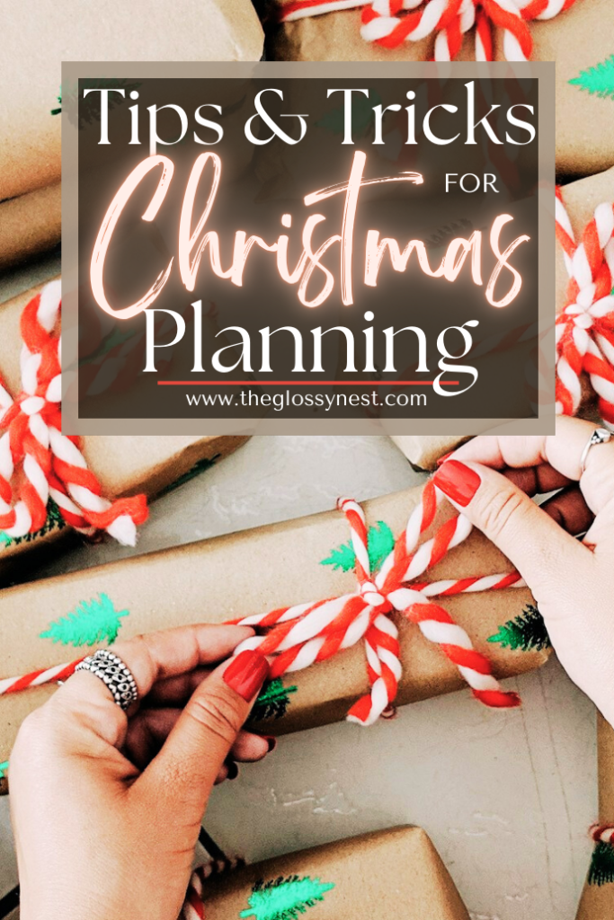 Hands with red nails tie red and white string around brown paper-wrapped gifts with green tree stamps. Text overlay reads "Tips & Tricks for Christmas Planning" with website URL below.