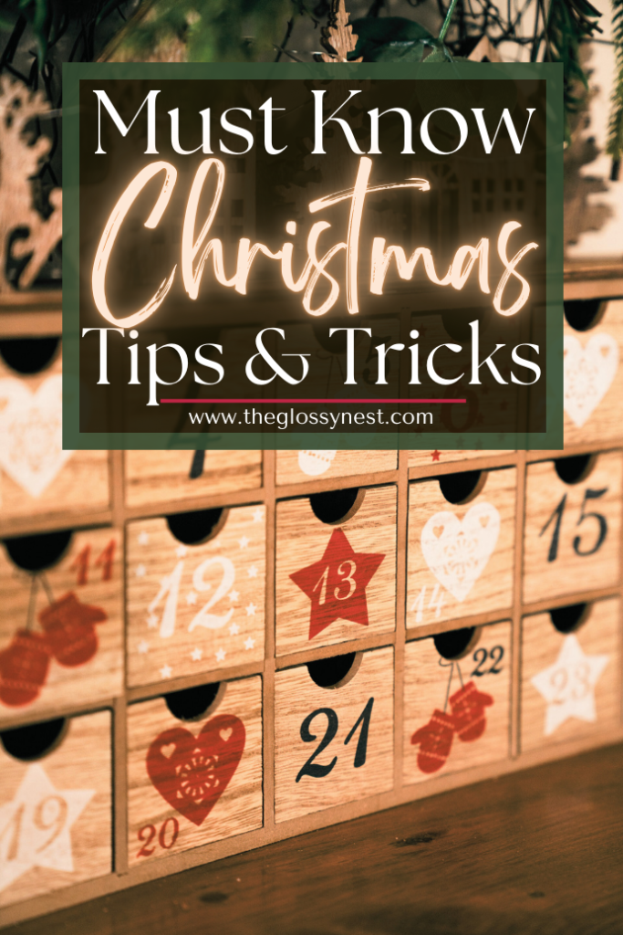 A wooden advent calendar with numbered drawers from 1 to 24, decorated with red stars and heart designs. Above it, text reads "Must Know Christmas Tips & Tricks" with the website address "www.theglossynest.com.