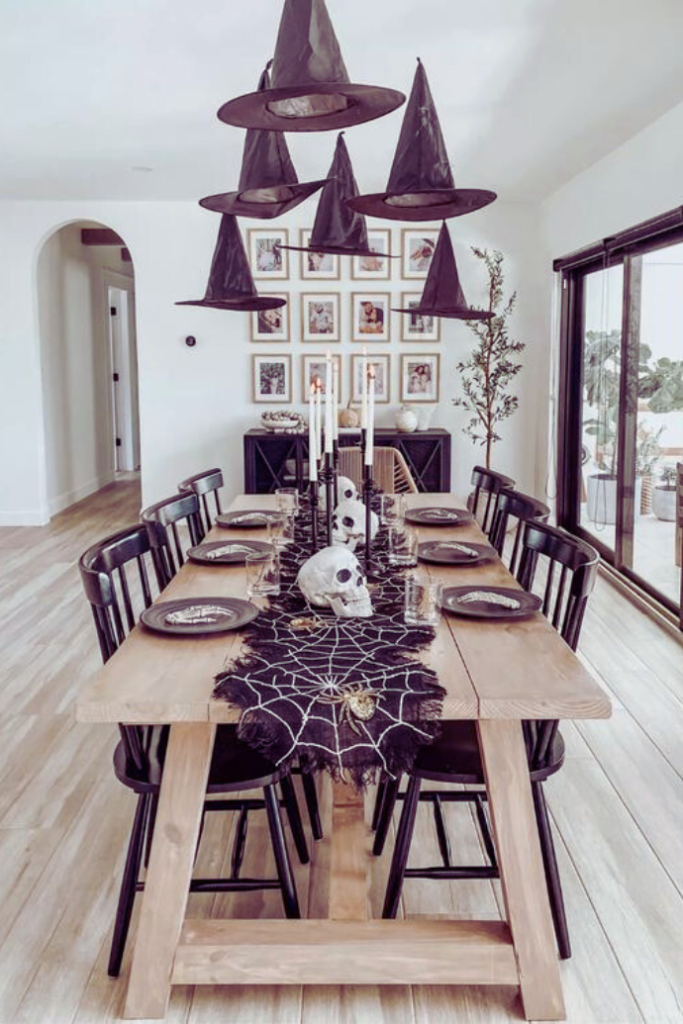 farmhouse halloween tablescape with skeletons, witch hats