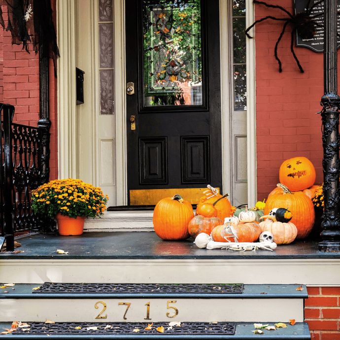 halloween decor ideas with pumpkins, bones, mums, spiders on front porch