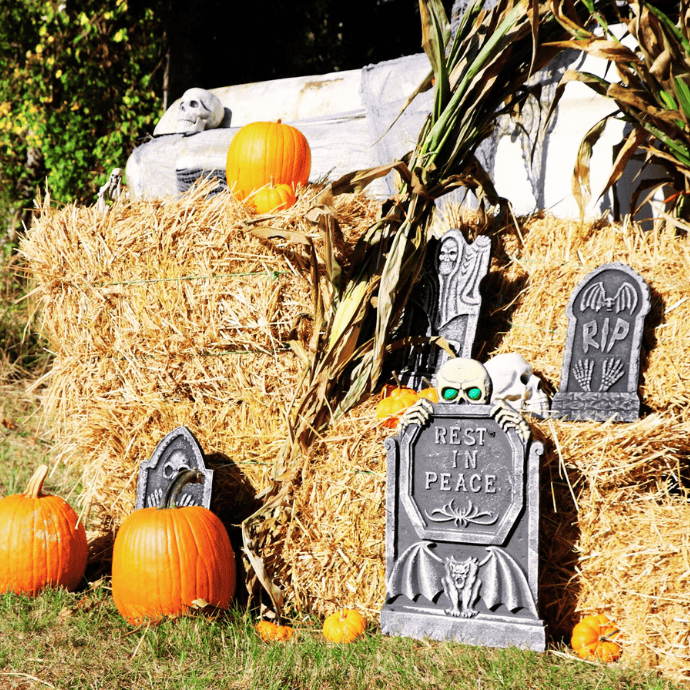 halloween decoration ideas with hay bales, faux tombstones, pumpkins