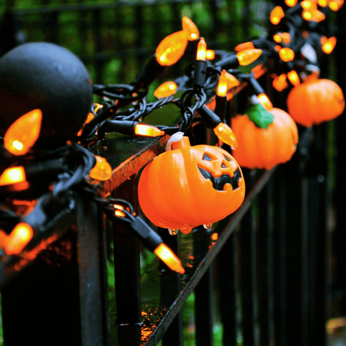 halloween decoration ideas with orange pumpkin string lights on fence