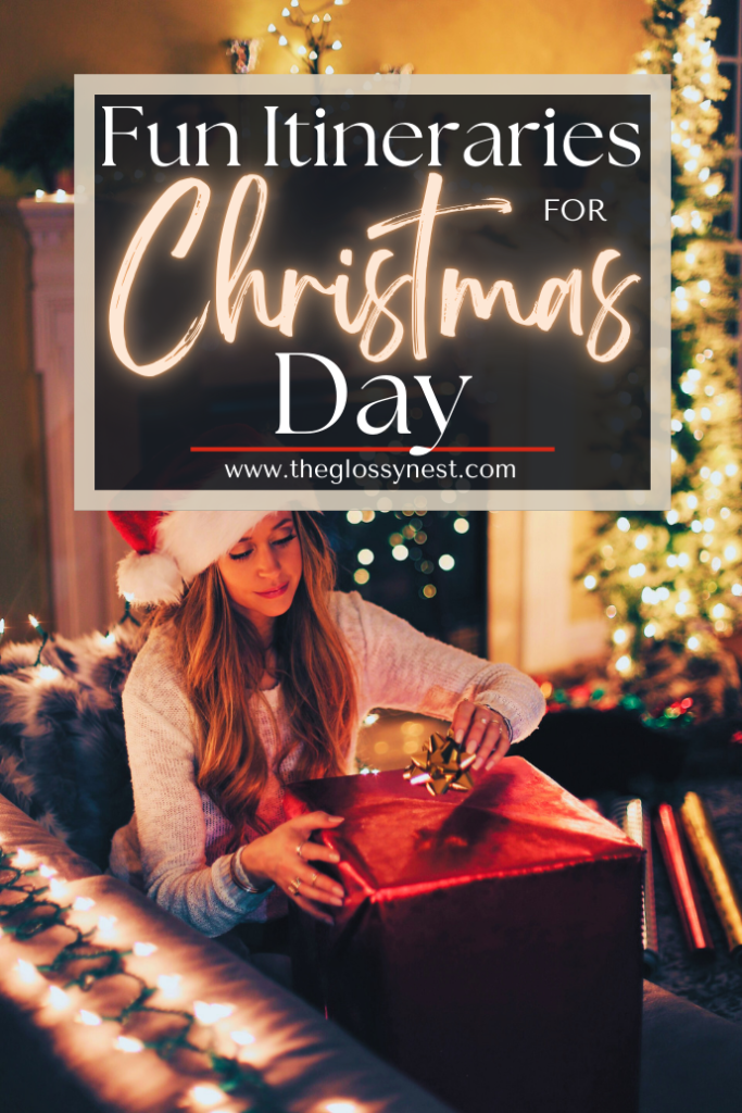 A woman sits in a cozy, festive room with Christmas lights, wearing a Santa hat and holding a wrapped gift. Text overlay reads, "Fun Itineraries for Christmas Day. www.theglossynest.com."