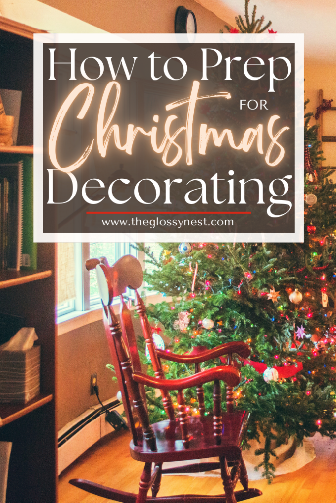 A cozy room features a decorated Christmas tree with colorful lights and ornaments near a wooden rocking chair. Text overlay reads, "How to Prep for Christmas Decorating: www.theglossynest.com".