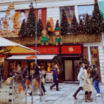 People Christmas shopping on a high street decorated with Christmas decorations.