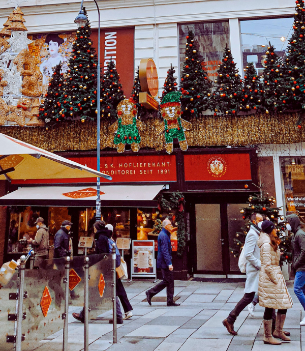 People Christmas shopping on a high street decorated with Christmas decorations.